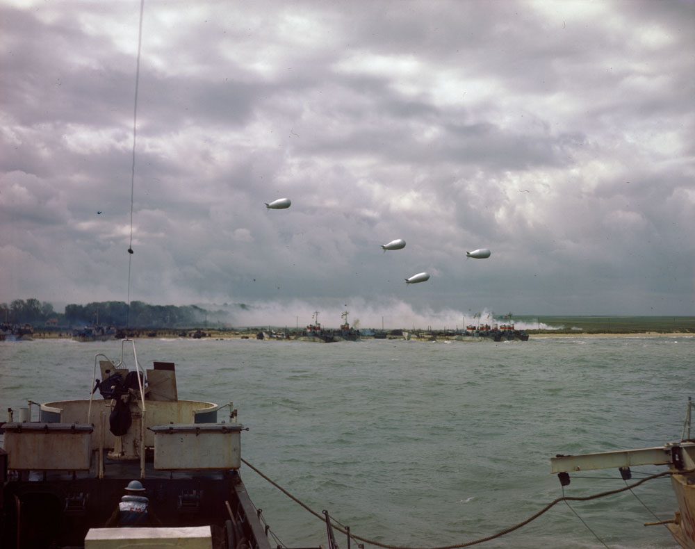 une image prise depuis une péniche de débarquement en route vers les plages de Normandie.Dans le ciel, des ballons militaires.