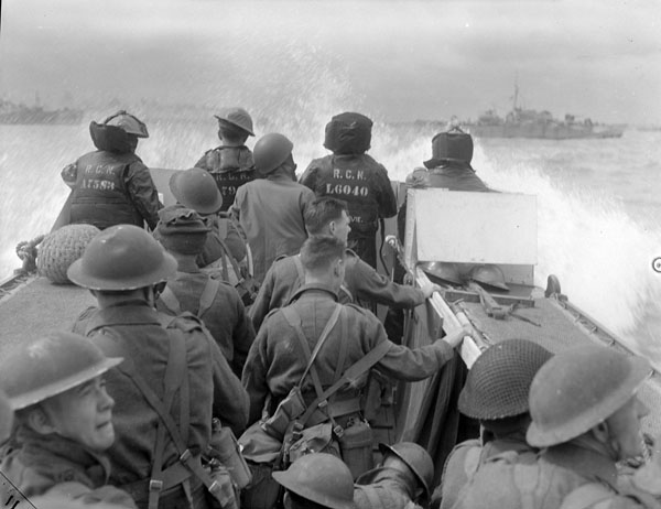 Image prise depuis une péniche de débarquement en route vers les plages de Normandie. Il y a des soldats dans la péniche de débarquement et ils sont tous tournés vers l'arrière de l'appareil photo.