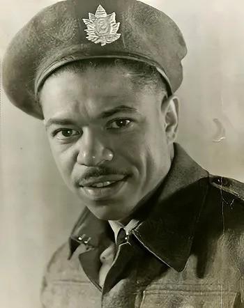 Portrait en noir et blanc d'un soldat en uniforme.Il porte une moustache. Son insigne de casquette est une feuille d'érable sur laquelle figure le chiffre 2.