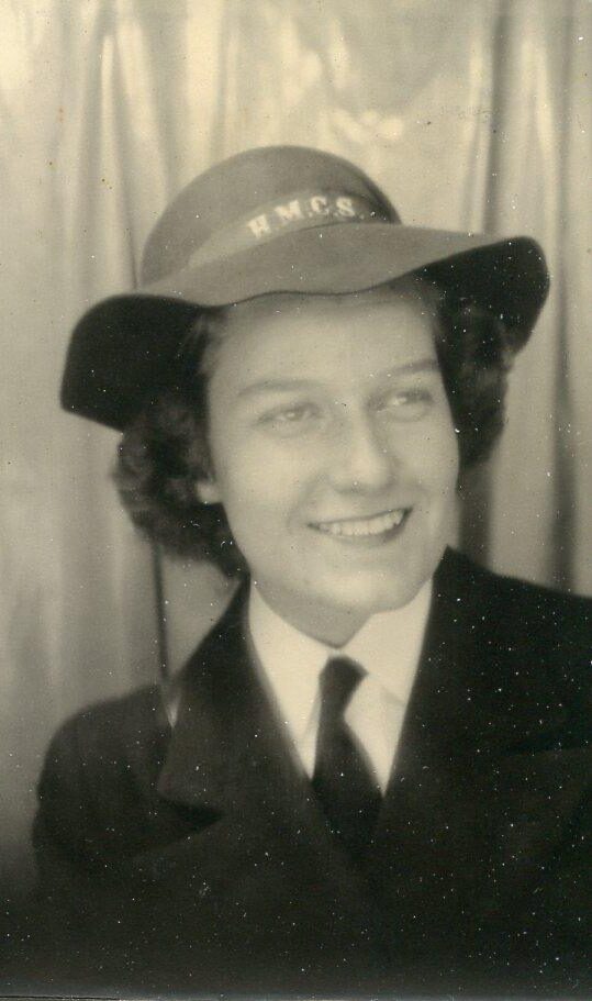 Portrait en noir et blanc d'une femme souriante en uniforme militaire.Elle porte un chapeau à larges bords.
