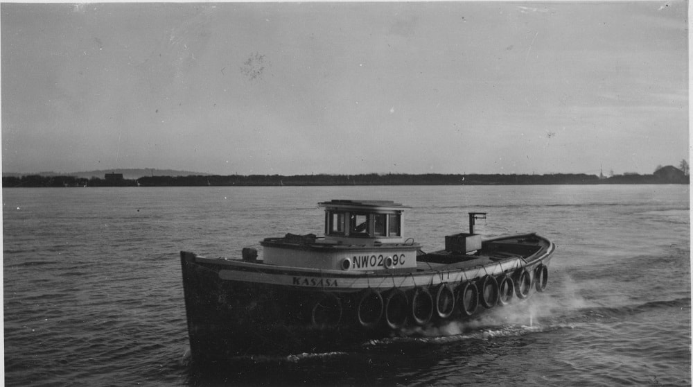 Image d'un bateau se déplaçant sur une étendue d'eau. Le bateau porte le nom de « Kasasa ».