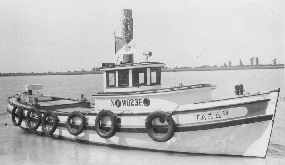 Image d'un bateau sur l'eau. Le nom du bateau est TAKA IV.