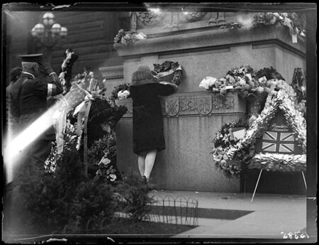 Une femme déposant une couronne de fleurs lors du jour de l’Armistice à Toronto, en 1928. 