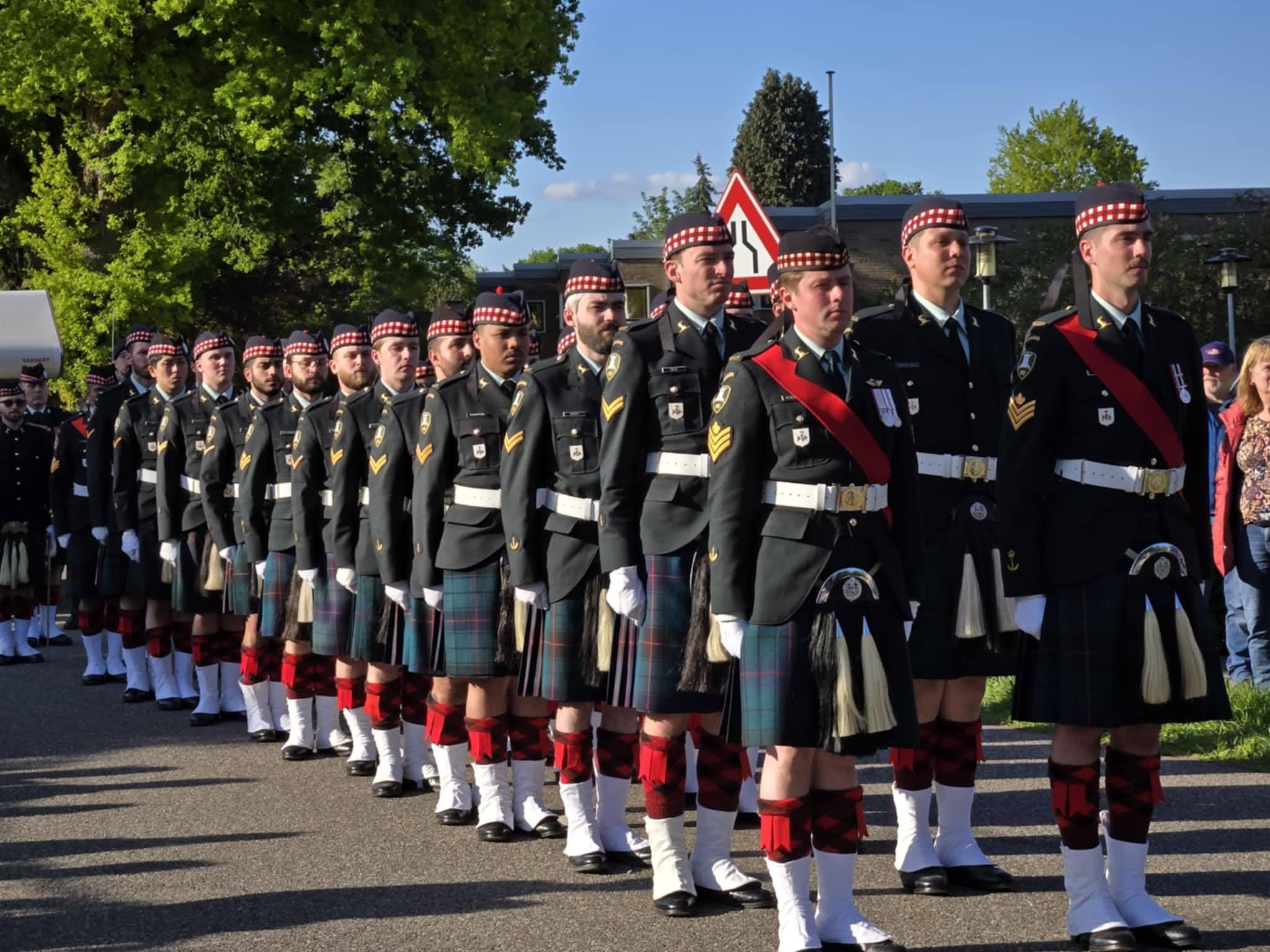 A group of soldiers in uniform in two straight lines. They are all standing at attention.