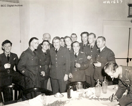 Un groupe d'aviateurs en uniforme debout derrière une table. Beaucoup ont des brûlures. Ils sourient.