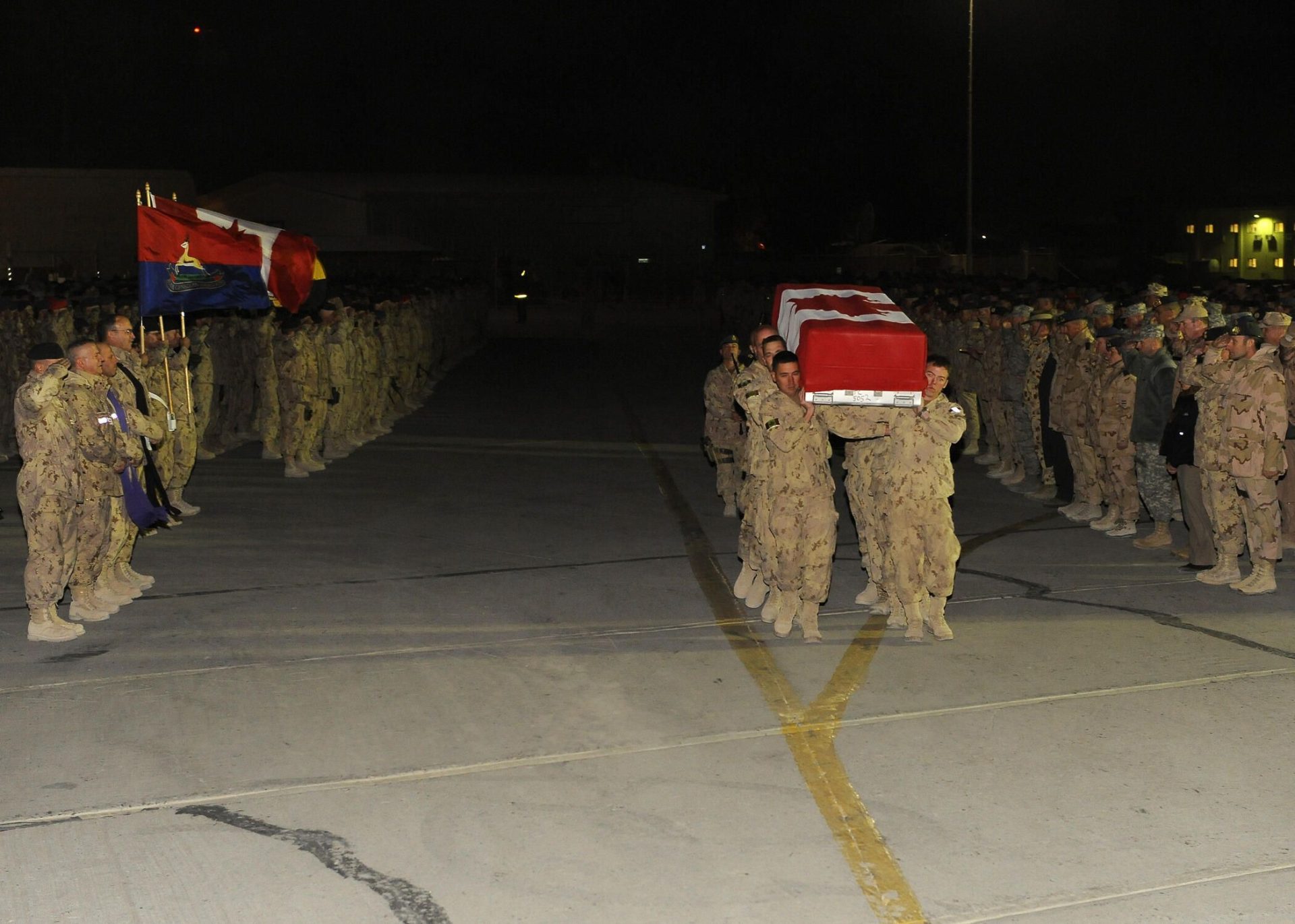Canadian soldiers carrying a coffin draped in a Canadian flag.