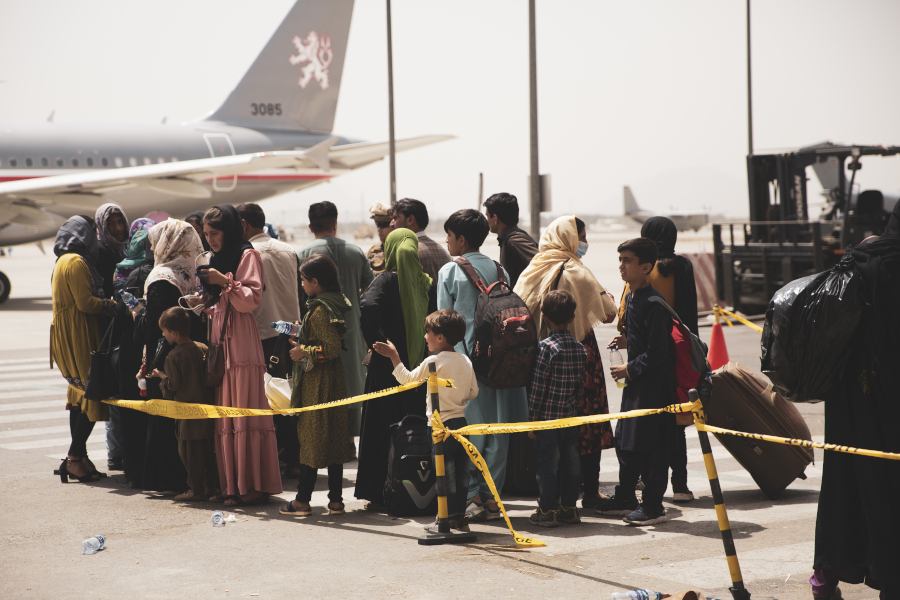 Des civils afghans font la queue pour monter à bord d'un avion.
