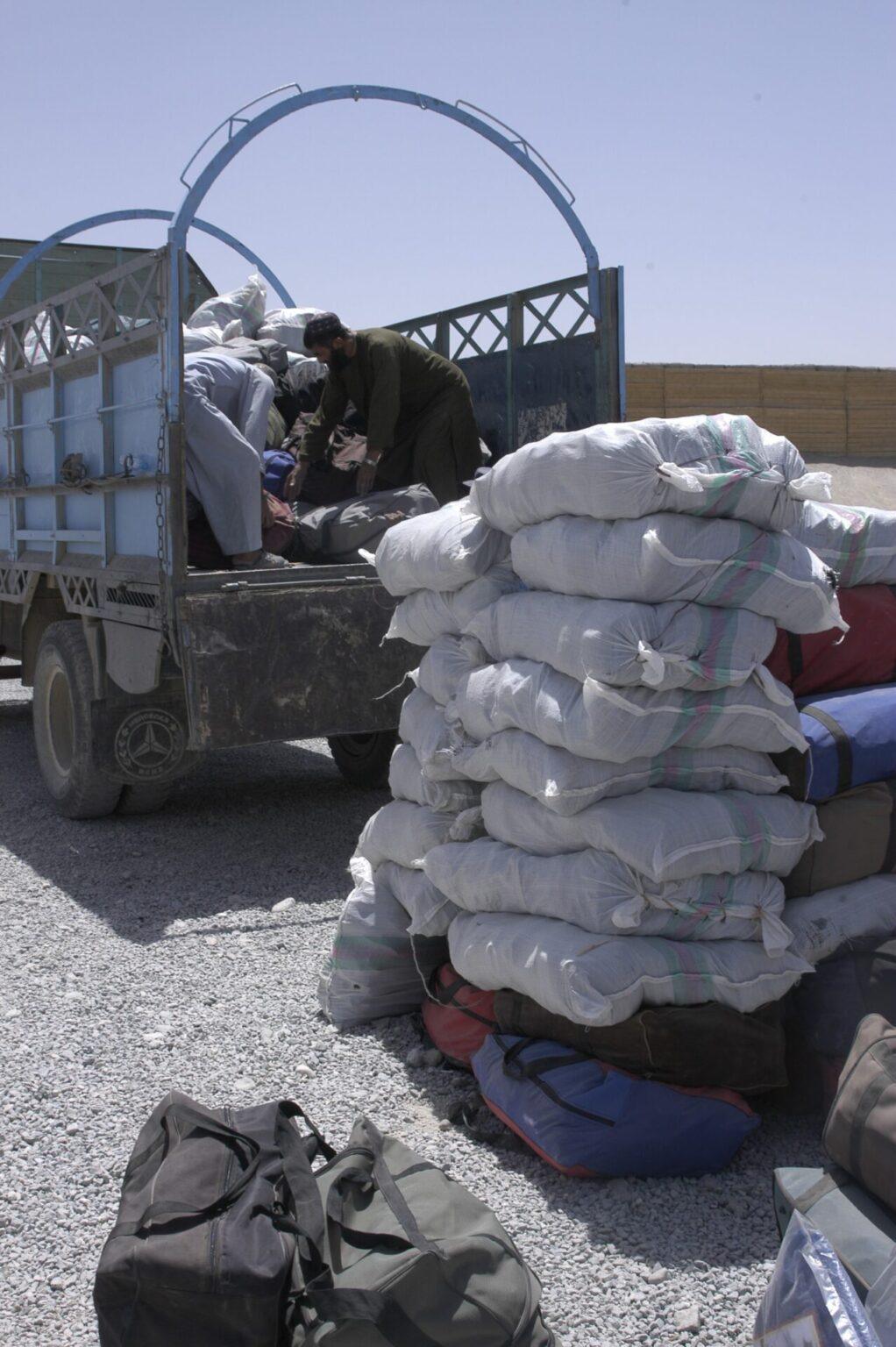 des hommes déchargent des provisions d'un camion.