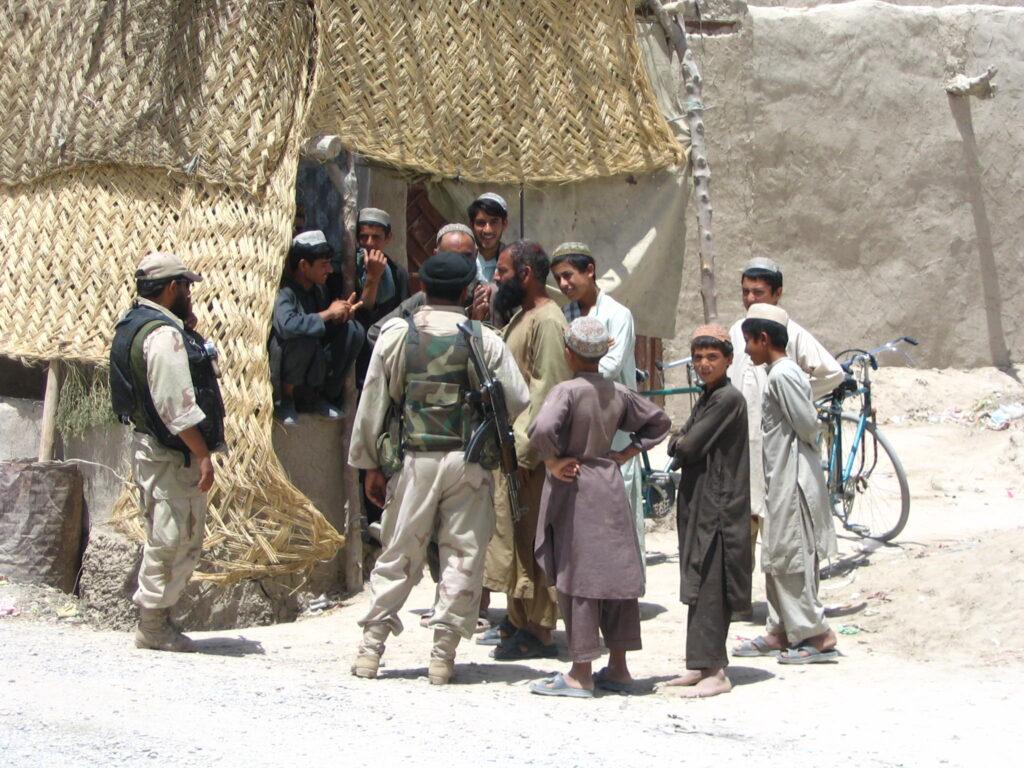 des soldats s'adressant à des membres du public afghan.