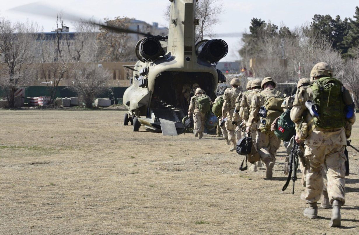 Des soldats canadiens montant à bord d'un avion.