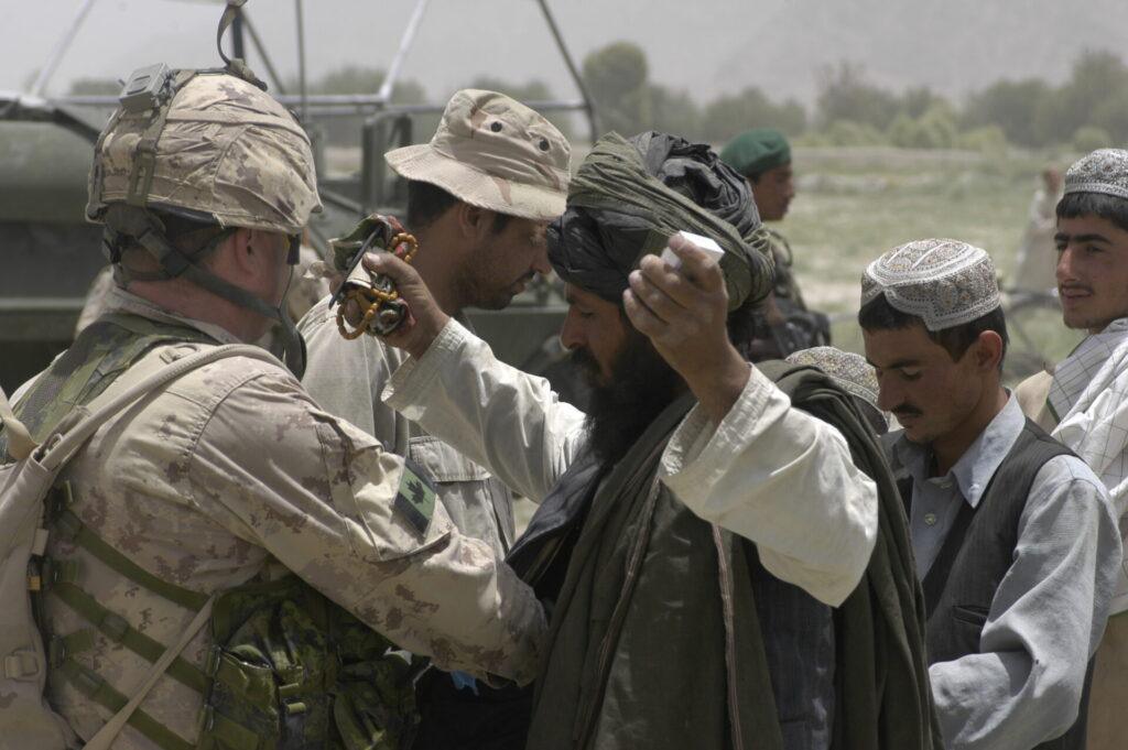 Un soldat fouille un Afghan.