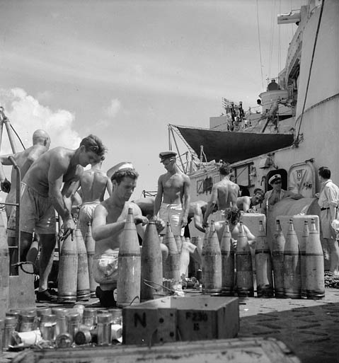 Un groupe de marins près d'un navire. Certains préparent le matériel.