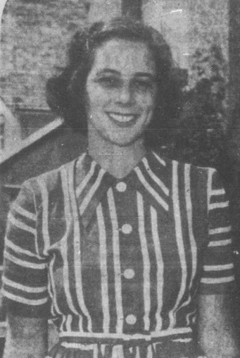 Une femme en robe rayée qui sourit.
