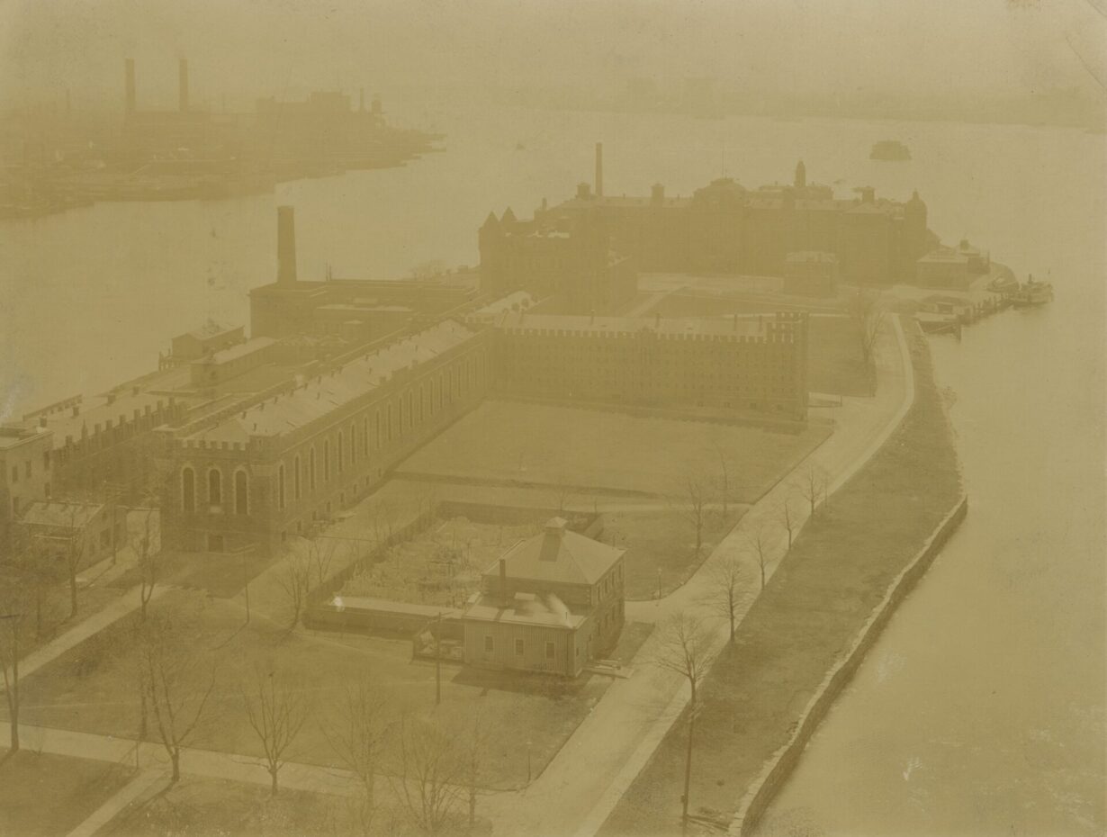 An aerial view of a group of brick buildings on an island.